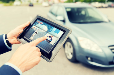 close up of hands with news on tablet pc and car