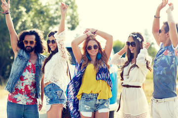 happy young hippie friends dancing outdoors