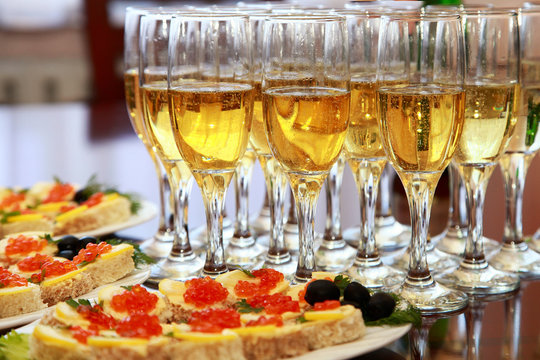 sandwiches with red caviar and champagne on the table