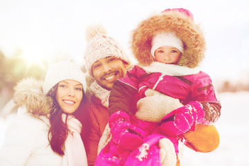 happy family with child in winter clothes outdoors