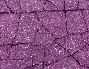 Damaged magenta toned old asphalt road.