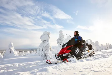 Fotobehang Man driving snowmobile in Finland © kobeza