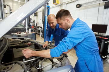 mechanic men with wrench repairing car at workshop
