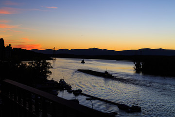 Fototapeta na wymiar Hudson River at dusk in Hudson with lighthouse and boats