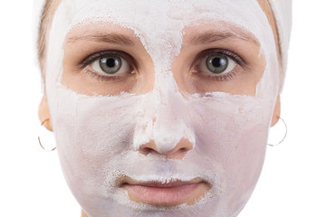 A young girl makes a face mask.
