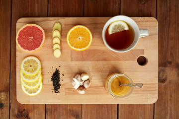 ginger tea with honey, citrus and garlic on wood