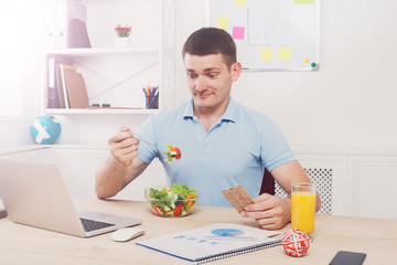 Man has healthy business lunch in modern office interior