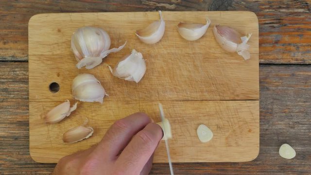 Chopping garlic on a rustic wooden table - flat lay 4K