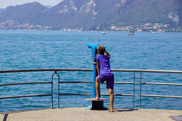 guy watches the panorama using the telescope. admire the view is one of attrazzioni available at tourist sites