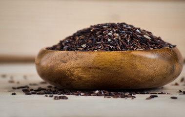 Riceberry in a wooden bowl on wooden background, basmati rice, white rice, rice photo, raw rice.