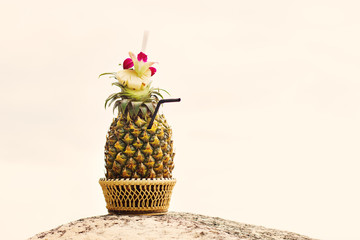 Exotic cocktail in a pineapple on a beach