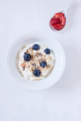 muesli with berries and yogurt on a white backgrund