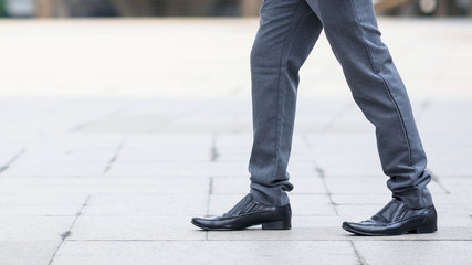 Fototapeta premium Businessman crossing the street on crosswalk