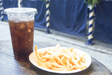 french fries and cola on wooden table street food
