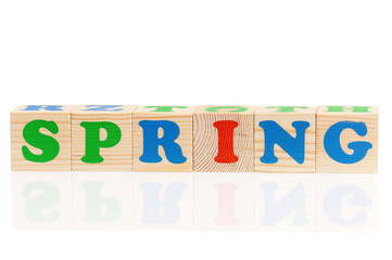 Spring word formed by colorful wooden alphabet blocks, isolated on white background 