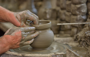 Hands working on pottery wheel