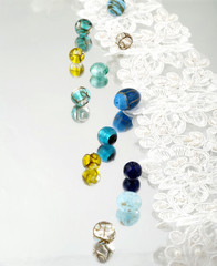 Shimmering glass beads and vintage lace on mirror background 