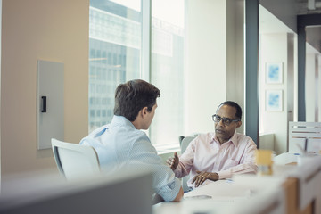 Two businessmen talking together in office