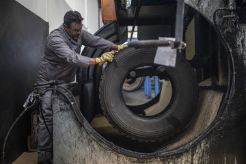 Repairman working on tire in factory