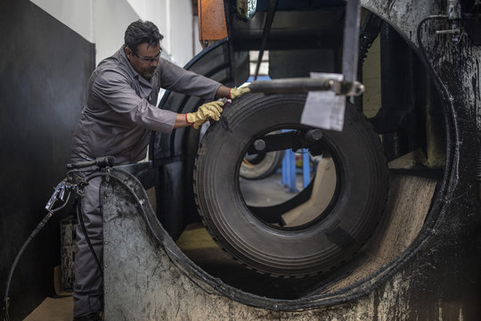 Repairman working on tire in factory