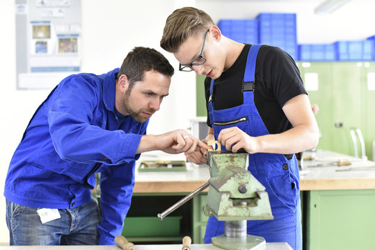 Instructor with trainee at workbench
