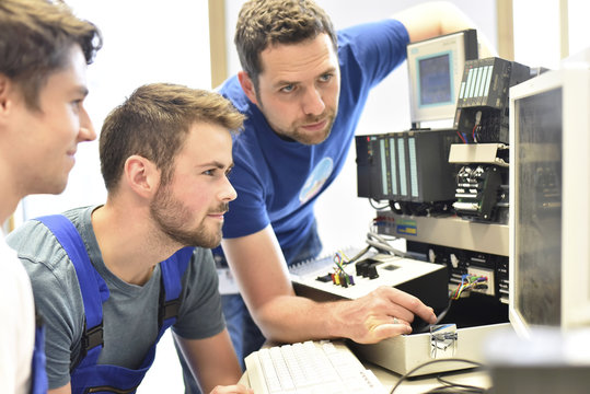 Technical instructor teaching students at computer screen