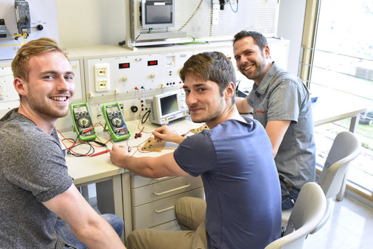 Portrait of smiling students with technical instructor