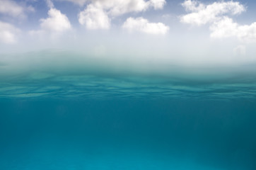 Underwater scene in the bottom and sky with clouds on the top