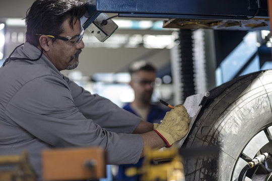 Tire repairmen writing on clipboard