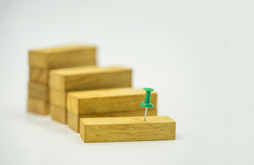 abstract green pin point to start on wood block stair isolate