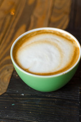 Tasty hot coffee in the green cup