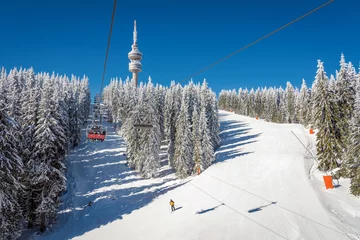 Foto op Plexiglas Wintersport Winter resort with ski lift and ski tracks and the Snejanka tower -  Pamporovo, Bulgaria