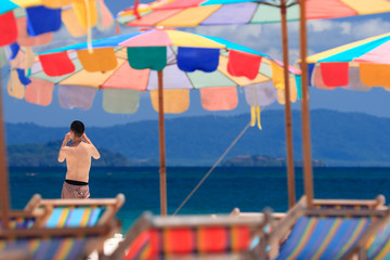 Man taking photo by the beach at Koh Khai island. Phuket, Thailand.