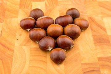 Autumn seasonal fruit Spanish Chestnuts on a wooden plate formed