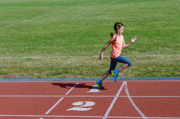 Fototapeta premium Kids sport, child running on stadium track, training and fitness concept 