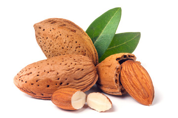 almonds in their skins and peeled with leaf isolated on white background