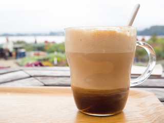 Hot caramel coffee latte on wood table at Kawaguchiko lake, Japan