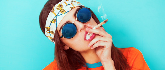 Hipis portret dziewczyny palenie chwastów i noszenie okularów przeciwsłonecznych letterbox - 125729979