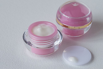 
 Two jars of cosmetic cream.  Two jars of cosmetic cream for facial skin care on a light background.