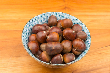 Spanish Chestnuts in a vintage dish on wooden plate background
