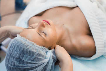 Young woman enjoying facial at spa salon