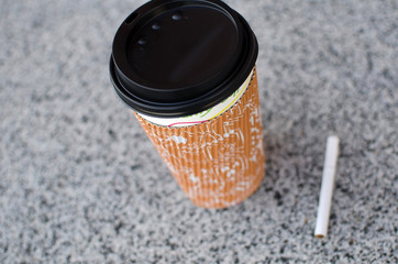 Cigarette next to plastic cup