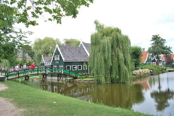 Obraz premium Traditional Dutch old wooden windmill in Zaanse Schans - museum village in Zaandam (Traditional village in Holland in Netherlands)