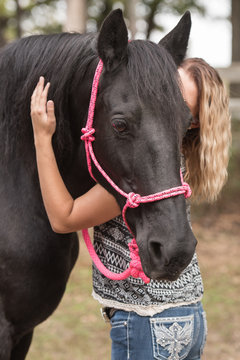 Blonde Woman Giving A Black Horse A Hug