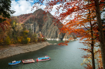 Colorful fall landscape. A boat on a mountain lake in autumn forest.