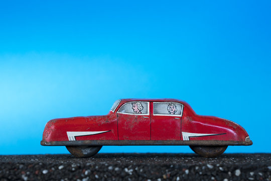 Red vintage toy car on blue background