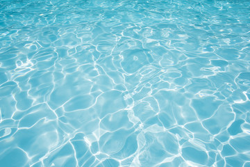 Naklejka na ściany i meble Blue water surface in swimming pool witn sun reflection