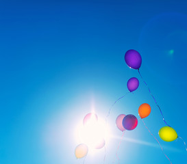 Many colorful baloons in the blue sky. Place for your text.