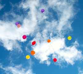 Many colorful baloons in the blue sky.