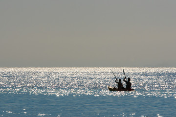 Fototapeta premium Silhouette of a couple on a boat in the sea at sunrise. Koh Rok island, Krabi, Thailand.
